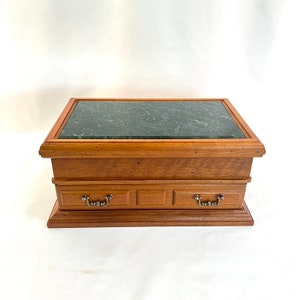 May include: A wooden jewelry box with a green marble top and two drawers. The box has a brown wood finish and silver drawer pulls.