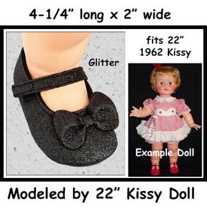 May include: Black glitter doll shoes with a bow, measuring 4.25 inches long and 2 inches wide. The shoes are designed to fit a 22-inch 1962 Kissy doll. The text "Glitter" and "Example Doll" are also visible.