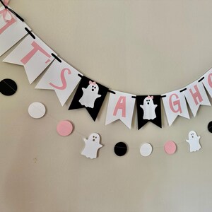 以下が含まれることがあります： ピンクと黒の旗に幽霊と「It's a ghoul」の文字が書かれた「It's a ghoul」の旗