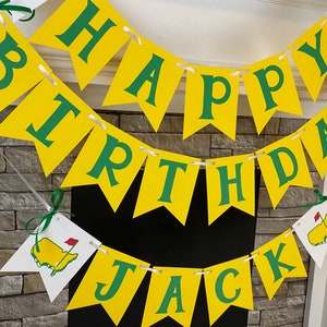May include: A yellow and green banner with the words "Happy Birthday Jack" on it. The banner is decorated with green shamrocks and a small green and red golf flag.