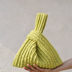 Peut inclure: Un sac cabas en crochet vert lime avec une poignée nouée.