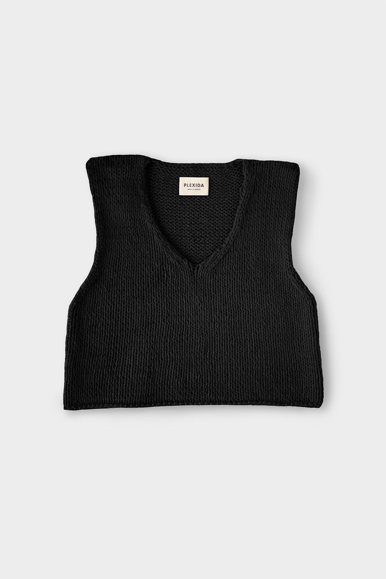 May include: Black sleeveless knitted vest with a V-neck and a small label that reads "PLEXIDA MADE IN GREECE".