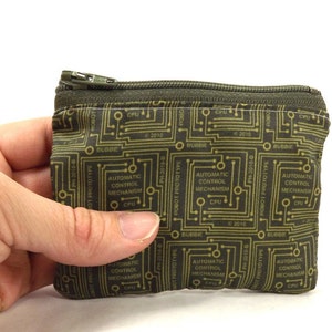 May include: A small green zippered pouch with a circuit board pattern. The pattern is in gold and features the text "ROBOT PROTOTYPE PH-2010-B" and "AUTOMATIC CONTROL MECHANISM CPU".