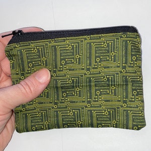 May include: A black zippered pouch with a green and yellow circuit board pattern. The pattern repeats the text "ROBOT PROTOTYPE" and "AUTOMATIC CONTROL MECHANISM CPU".