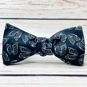 May include: A black bow tie with a white anatomical lung pattern.