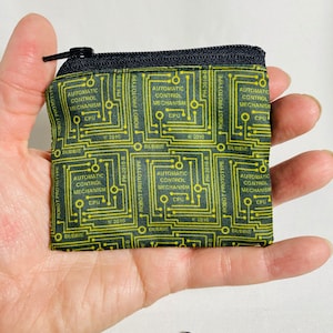 May include: A black zippered pouch with a green and yellow circuit board pattern. The pouch has the text "ROBOT PROTOTYPE" and "AUTOMATIC CONTROL MECHANISM" repeated on it.
