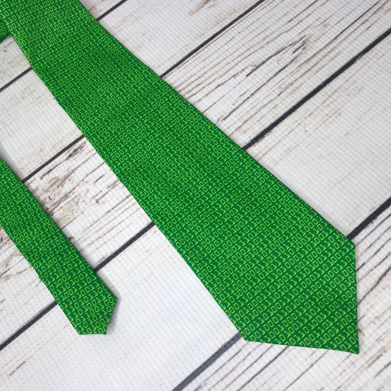 K&ouml;nnte beinhalten: Eine gr&uuml;ne Krawatte mit einem Muster aus gelbem Bin&auml;rcode.