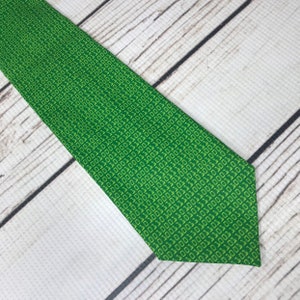 K&ouml;nnte beinhalten: Eine gr&uuml;ne Krawatte mit einem Muster aus wiederholtem Bin&auml;rcode.