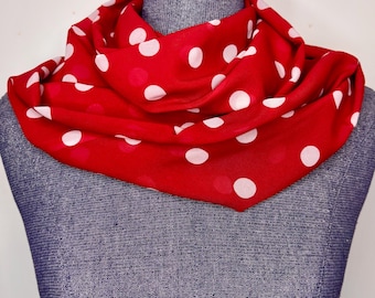 Peut inclure: Écharpe rouge à pois blancs drapée autour du cou d'un mannequin. Le foulard est en tissu doux et présente un motif à pois classique. Un accessoire polyvalent.