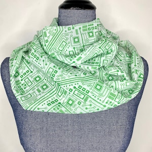 May include: A white infinity scarf with a green circuit board pattern.