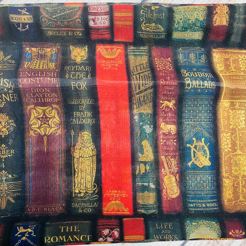 May include: A colorful fabric with a pattern of vintage book covers. The book titles include "English Costume", "Reynard the Fox", "Little Wide Awake", "Boudoir Ballads", and "Life and Works".