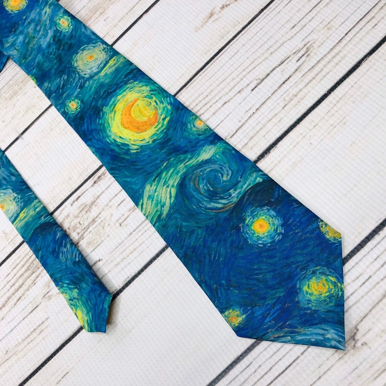 May include: A blue necktie with a print of Vincent van Gogh's "Starry Night" painting. The tie features swirling yellow and blue brushstrokes and a bright yellow moon.
