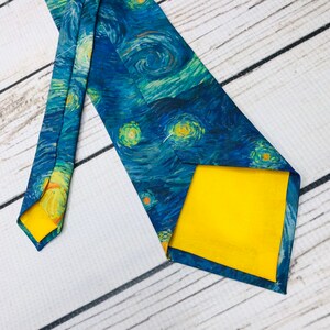 May include: A blue silk tie with a print of Vincent van Gogh's Starry Night. The tie has a yellow lining.