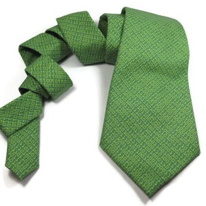 K&ouml;nnte beinhalten: Eine gr&uuml;ne Seidenkrawatte mit einem Muster aus wiederholtem Bin&auml;rcode in einem helleren Gr&uuml;nton.