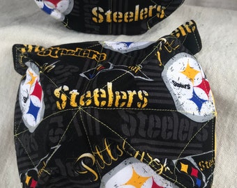 May include: A set of two black and yellow pot holders with a Pittsburgh Steelers logo and the words "Steelers" and "Pittsburgh".