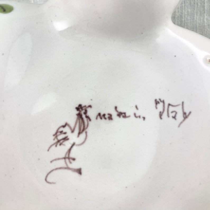 May include: A white ceramic dish with a brown hand-painted design of a bird and the text "made in Italy".