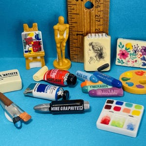 Może przedstawiać: Biały ceramiczny kubek z czarnym uchwytem i napisem "But First, Coffee" pogrubioną, czarną czcionką. Kubek jest umieszczony na rozmytym tle, podkreślając jego czysty design.