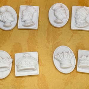 May include: Ten white ceramic oval and square shaped decorative tiles with raised images of crowns and people wearing crowns.
