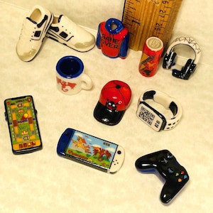 Equipamiento para videojuegos: Auriculares, zapatillas, gorra de béisbol, mando, taza, reloj, teléfono móvil, casco - Miniaturas francesas Feves para casa de muñecas X120