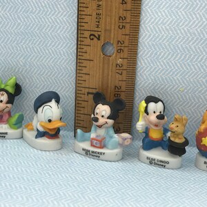 Może przedstawiać: Zestaw pięciu porcelanowych figurek postaci z Disneya, w tym Myszki Miki, Minnie Mouse, Kaczora Donalda, Goofy'ego i Pluto. Każda figurka ma około 5 cm wysokości i przedstawia postać w dziecięcej pozie. Figurki są pomalowane żywymi kolorami i mają błyszczące wykończenie.