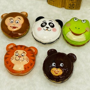 May include: Five small ceramic animal figurines, each with a different animal face. The animals are a monkey, panda, frog, tiger, and bear. The figurines are all brown, black, green, orange, and brown.