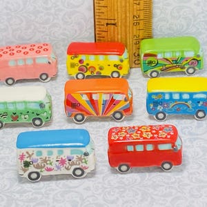 Peut inclure: Ensemble de dix mini-bus Volkswagen en céramique avec différents motifs colorés, notamment des fleurs, des cœurs, des arcs-en-ciel et des motifs géométriques.