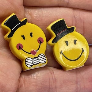 2 kleine gele lachende gezicht man en vrouw hoge hoed plat met standaard Franse Feve Feves porseleinen beeldjes poppenhuis bedel mini C108