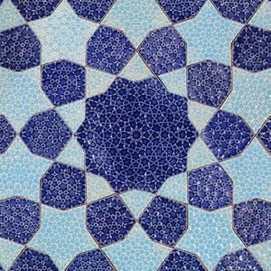May include: Close-up of a repeating pattern of blue and light blue star-shaped tiles. The tiles have a textured surface with a mosaic-like design. The pattern creates a symmetrical and visually appealing design, suitable for home decor.