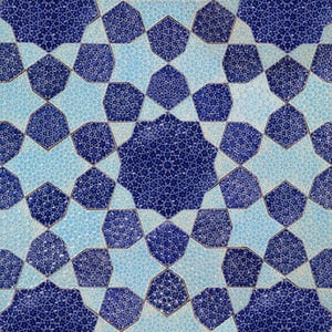 May include: Close-up of a decorative tile pattern featuring a repeating geometric design. The pattern uses shades of blue and light blue, creating a symmetrical star-like motif. The intricate design is suitable for home decor.