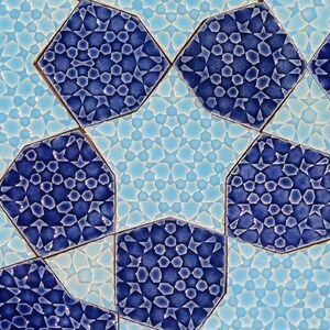 May include: Close-up of a decorative tile pattern featuring geometric shapes in shades of blue and light blue. The design includes octagonal tiles with intricate star and floral patterns, creating a visually appealing mosaic.