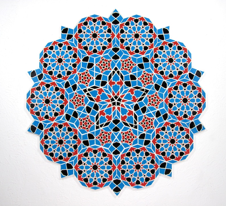 May include: A circular, geometric design featuring a complex pattern of interlocking shapes. The design is primarily blue, with red and black accents, creating a visually striking and symmetrical artwork. The piece is set against a white background.