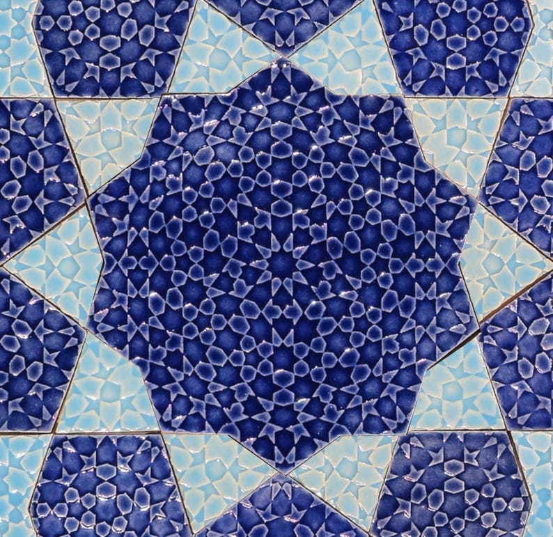 May include: Close-up of a mosaic tile pattern featuring a central eight-pointed star in deep blue, surrounded by lighter blue and turquoise star shapes. The intricate design is composed of small, geometric shapes.