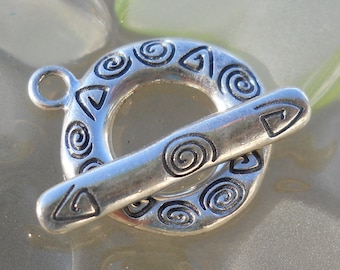 May include: Silver-toned toggle clasp with a decorative design of spirals and triangles. The clasp is designed to be used for jewelry making.