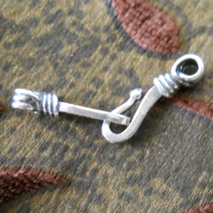 May include: Silver clasp with a twisted design and a hook closure.