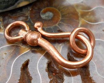 May include: A copper swivel clasp with a round loop and a hook. The clasp is a shiny copper color and has a smooth finish.