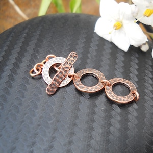 May include: A copper and silver toggle clasp with three hammered circles. The clasp is designed for jewelry making.
