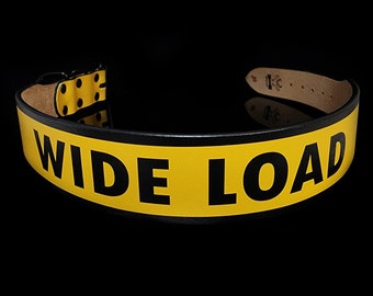 May include: A black leather belt with a yellow stripe that says "WIDE LOAD" in black letters.