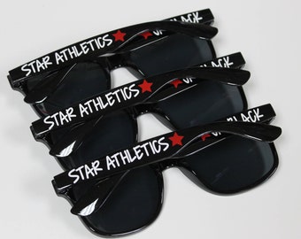 May include: Three black sunglasses with red stars and the words "STAR ATHLETICS" printed on the arms.
