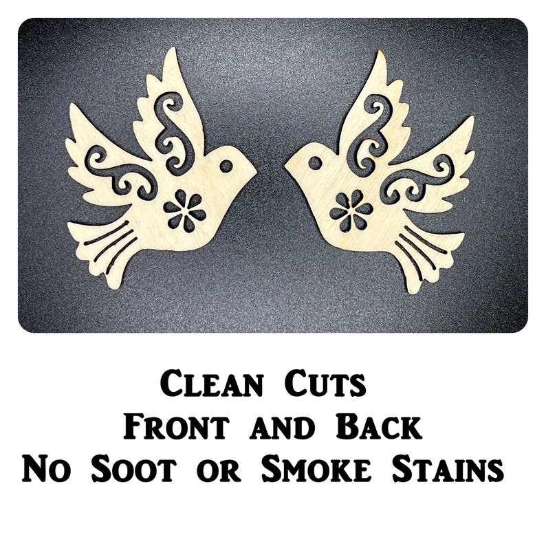 Op de afbeelding: Twee houten duiven met ingewikkelde ontwerpen, uitgesneden uit hout. De duiven kijken elkaar aan en hebben een bloemdessin in het midden van hun borst. De tekst "CLEAN CUTS FRONT AND BACK NO SOOT OR SMOKE STAINS" is onder de duiven gedrukt.