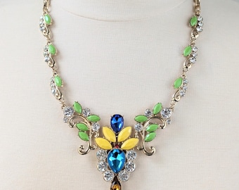 Collar floral de diamantes de imitación en azul menta: cadena con flores azules y amarillas y hojas doradas.