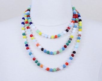 May include: Multi-strand necklace with colorful faceted beads. The necklace is made of several strands of beads in various colors, including red, blue, green, yellow, and pink.