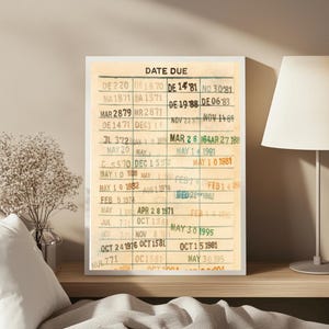 Peut inclure: Une carte de bibliothèque vintage encadrée avec les mots "DATE DUE" en haut. La carte comporte plusieurs entrées manuscrites avec des dates et des numéros, ce qui lui donne un aspect nostalgique. Le cadre est blanc.