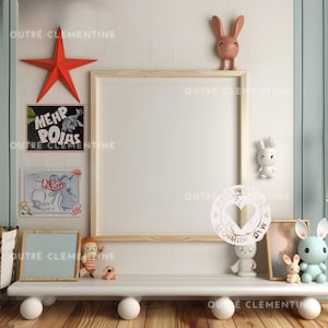 Op de afbeelding: Een wit rek met afgeronde randen staat op een houten vloer. Het rek is versierd met een rode ster, een ingelijst wit bord, een ingelijste illustratie van een cartoonfiguur, een ingelijste illustratie van een cartoonfiguur, een knuffel, een wit konijnenbeeldje, een wit konijnenbeeldje, een wit konijnenbeeldje en een ingelijste illustratie van een sterrenstelsel. Het rek is gelabeld "OUTRE CLEMENTINE".