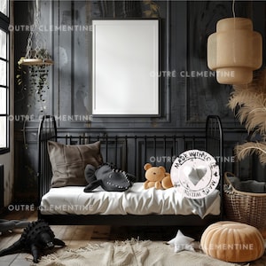 Op de afbeelding: Een zwart metalen dagbed met een wit matras en kussens. Een bruine teddybeer zit op het bed met een zwart-witte pluche vis. Een witte ronde sticker met de tekst "Made With Love" zit op het bed. Een bruine rieten mand en een bruin-oranje voetenbank staan op de vloer.