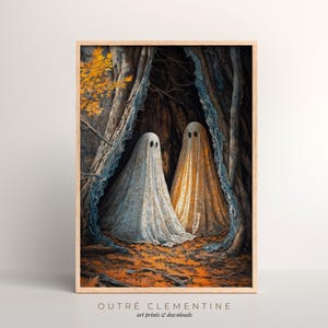 May include: A framed art print featuring two ghost figures in a forest setting. The ghosts are draped in white and gold fabric, with black eye holes. The artwork has a vintage aesthetic, with the text "OUTRÉ CLEMENTINE art prints & downloads" at the bottom.