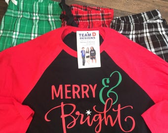 May include: A red and black long-sleeved shirt with the text "Merry & Bright" in green and red lettering. The shirt is paired with three pairs of plaid pajama pants: green and white, red and black, and black and white.
