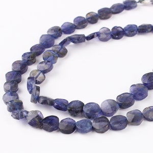 Peut inclure: Un collier de perles de pierres précieuses bleues, chaque perle est facetée et a une forme ovale légèrement irrégulière.