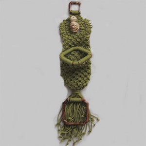 May include: A green macrame wall hanging with a wooden ring and a shell decoration. The hanging has a tassel at the bottom.