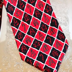 May include: A red and black patterned tie with a Christmas theme. The tie features a repeating pattern of Christmas trees, stars, snowmen, presents, and candy canes.