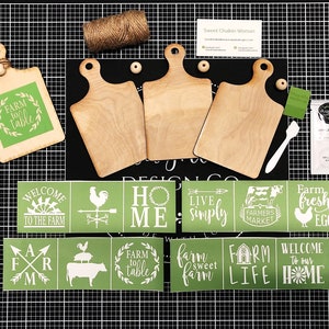 May include: A set of farmhouse-themed stencils for crafting. The stencils feature various designs, including "Farm to Table", "Welcome to the Farm", "Home", "Live Simply", "Farmers Market", "Farm Fresh Eggs", "Farm Sweet Farm", "Farm Life", and "Welcome to Our Home".
